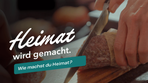 Eine Detailaufnahme von einer Ahle Wurst die auf einem Brettchen liegt und mit einem großem Messer angeschnitten wird. Dazu der Text "Heimat wird gemacht."